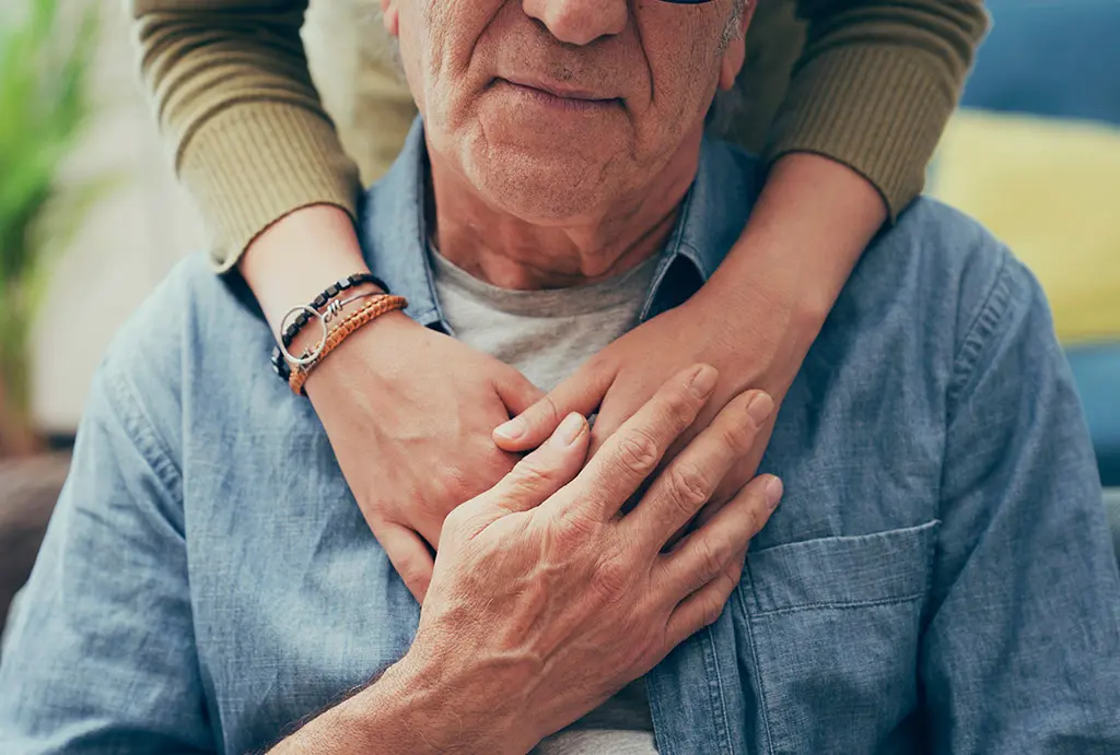 Comforting hands on shoulder of man