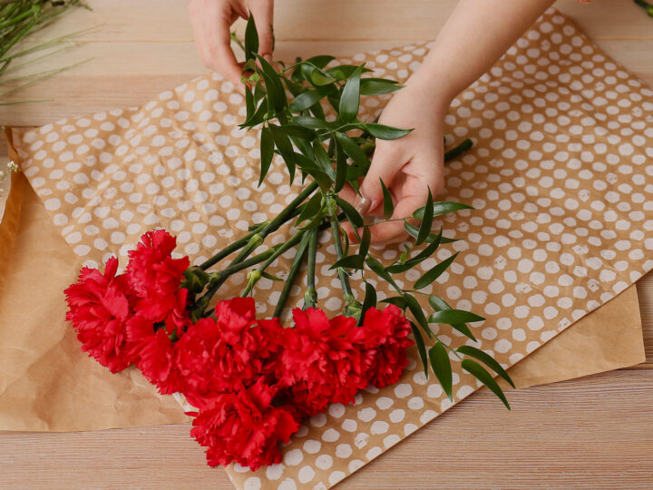 making a bouquet with red carnations